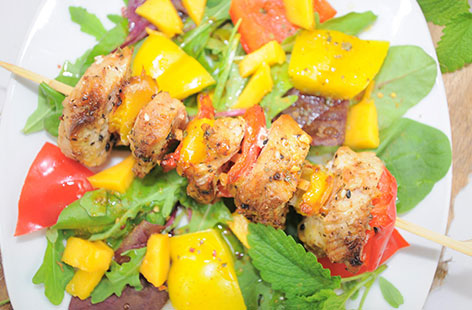 Hähnchenspieß vom Grill mit einem grünen Salat mit Mango
